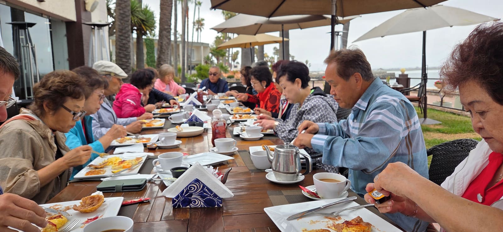 Mission-trip participants sharing breakfast near the water